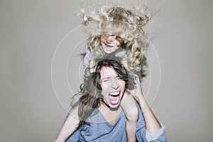 Woman is screaming and arguing with a child on his shoulders clinging to her hair