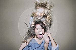 Woman is screaming and arguing with a child on his shoulders clinging to her hair