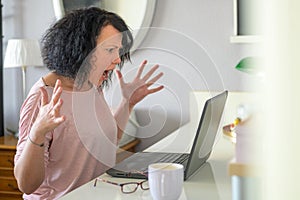 Woman screaming in front of her computer