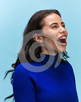 The woman screaming with open mouth isolated on blue background, concept face emotion