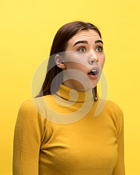 The woman screaming with open mouth isolated on yellow background, concept face emotion