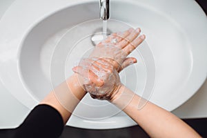 Woman scrubbing and washing hands at home . Hygiene and body cleaning concept detail