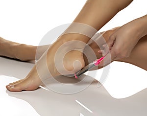 Woman scrubing her feet with a grater