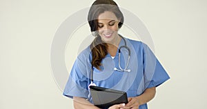 Woman in scrubs holds black portfolio and smiles