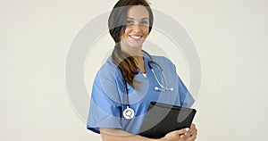 Woman in scrubs holds black portfolio and smiles