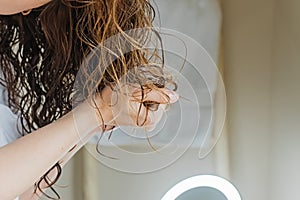 Woman scrunching her hair to form curls.