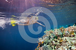 Woman scuba diver pointing to corals