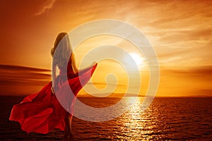 Woman on Sea Beach looking to Sunset Sky, Girl in Red Fluttering Dress, Rear back view
