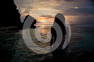 Woman on sea enjoying sunset on Bali