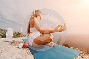 Woman sea pilates. Sporty happy middle-aged woman practices pilates on a beach near the sea, promoting a healthy