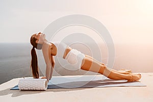 Woman sea pilates. Sporty middle-aged woman training in pilates on yoga mat by sea. concepts of health, wellness, and