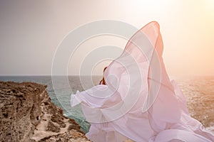 Woman sea white dress. Happy freedom woman on the beach enjoying and posing in white dress. Rear view of a girl in a