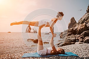 Woman sea yoga. Two happy women practicing yoga on the beach with ocean and rock mountains. Motivation and inspirational