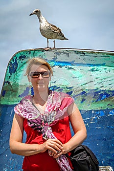 Woman and seagull in a port