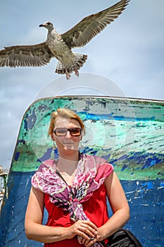 Woman and seagull in a port