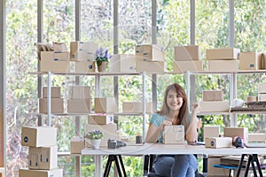 Woman sealing box to deliver products to customer