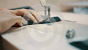 Woman seamstress works at a sewing machine