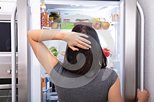 Woman Searching For Food In Refrigerator