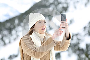 Woman searching phone coverage in winter