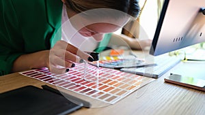 Woman searching proper colour for promotion and looking through magnifying glass