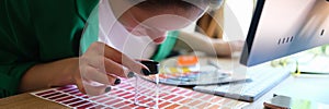 Woman searching proper colour for promotion and looking through magnifying glass