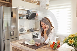 Woman searching for recipes while cooking lunch