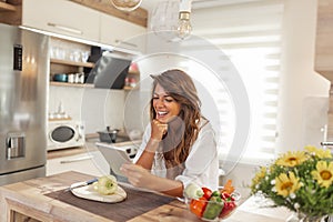 Woman searching for recipes while cooking lunch