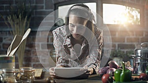 Woman searching recipes on her digital tablet