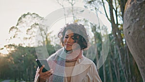 Woman searching smartphone signal in forest wearing casual autumn style closeup.