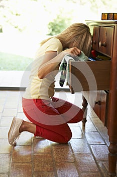 Woman Searching For Something In Drawers