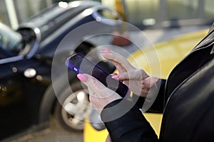 Woman searching for something on her phone after a car accident