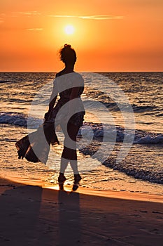 Woman on the seashore in a beautiful evening scenery.