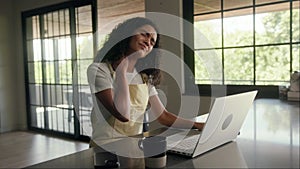 Woman seated at counter using laptop for work in a building