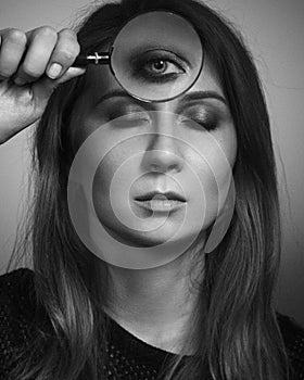 Woman see by third eye through magnifier glass. Black and white