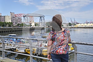 Woman seen from the back looking towards the Riachuelo, in La Boca, Buenos Aires photo