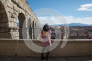 Woman at Segovia acueducto viewpoint during vacation in Spain - young happy woman visiting world heritage aqueduct in Segovia
