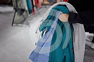 Woman selecting clothes in shop.Close up of hangers row.