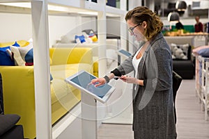 Woman with self-service device in the store