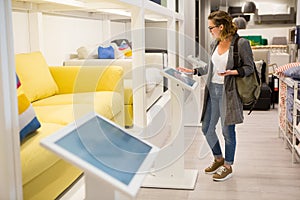 Woman with self-service device in the store