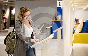 Woman with self-service device in the store