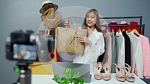 Woman selling bag and clothes online by camera live streaming, business online e-commerce at home