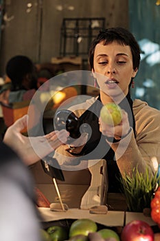 Woman selling eco organic fruits at local farmers market