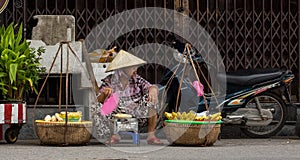 A woman selling foods on street in Hoi An, Vietnam