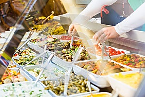 Woman selling Meze appetizers in delicatessen shop photo