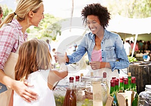 Woman Selling Soft Drinks At Farmers Market Stall