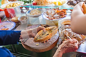 Woman selling street food Banh Mi at vendor in Vietnam