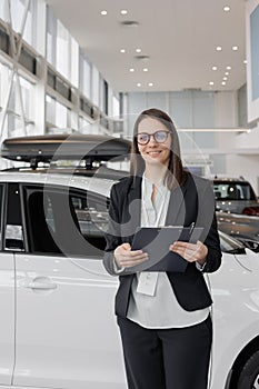 woman sells a car at a car dealership and hands over the keys to the buyer. nice woman car sales manager