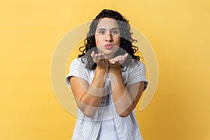 Woman sending air kiss to camera, flirting and demonstrating love affection feelings.