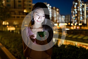 Woman sending sms on cellphone in the evening