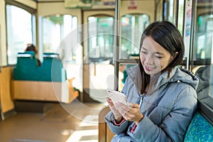 Woman sending sms on cellphone on train